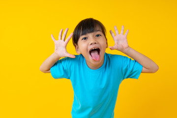 Portrait of young Asian girl expression and joyful, Thai kid have fun and innocence on yellow background