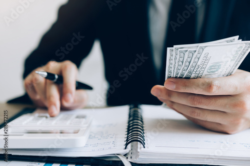 Fotomural Investors are calculating on calculator investment costs and holding cash notes in hand