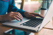 © wutzkoh - Man's hand is typing on the laptop keyboard.