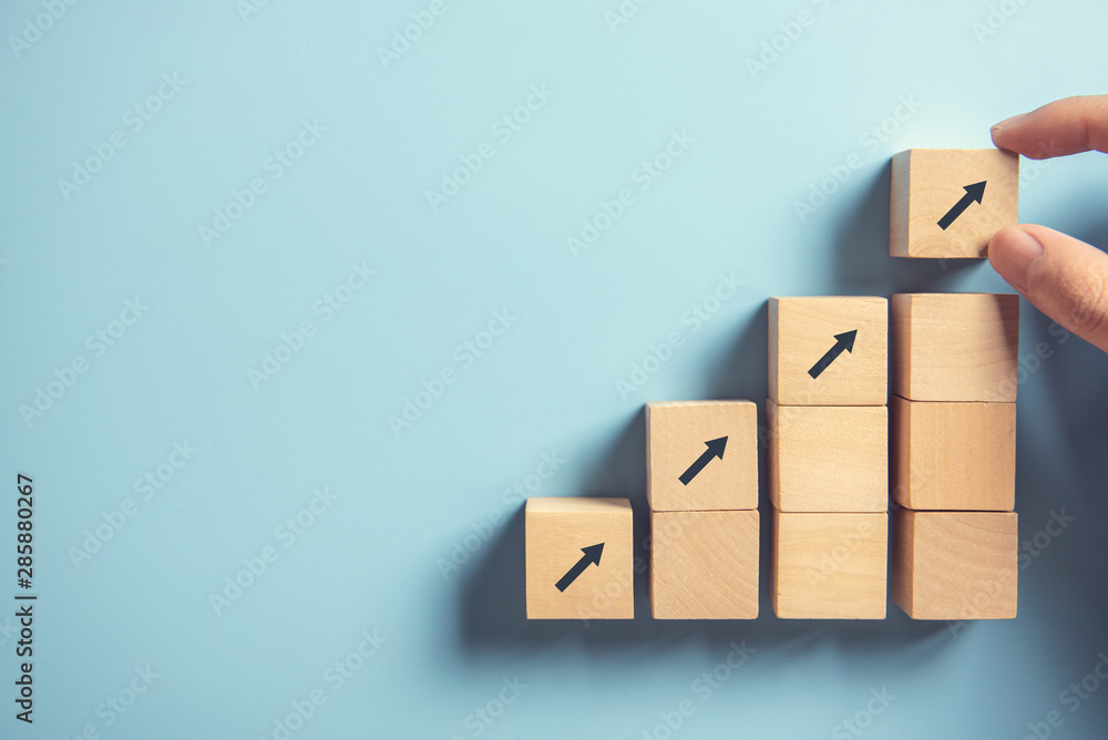Business concept growth success process, Close up Woman hand arranging wood block stacking as step stair on paper blue background, copy space. - obrazy, fototapety, plakaty 