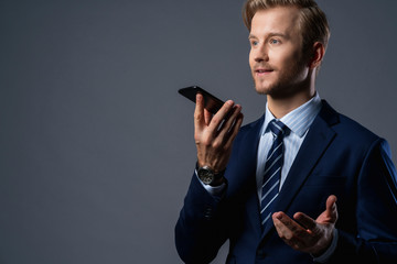 caucasian Successful businessman with beard close up mouse lip hand hold smartphone grey background