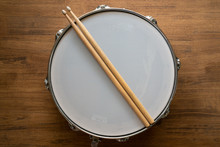 Drum Stick And Drum On Wooden Table Background, Top View, Music Concept