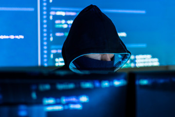 Wall Mural - man in hood and mask is hacking password, phishing. programmer developer is writing code malware sof