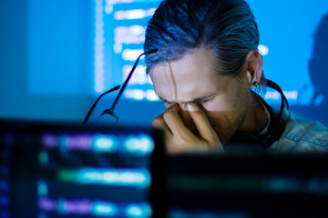 Wall Mural - young tired man freelancer in glasses is working at night because of deadline. programmer developer 