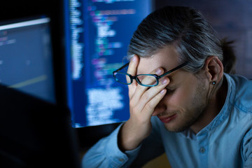 Wall Mural - young tired man freelancer in glasses is working at night because of deadline. programmer developer 