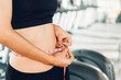 © sorapop - Beautiful woman using tape measuring waist, her is body slim after workout at fitness GYM