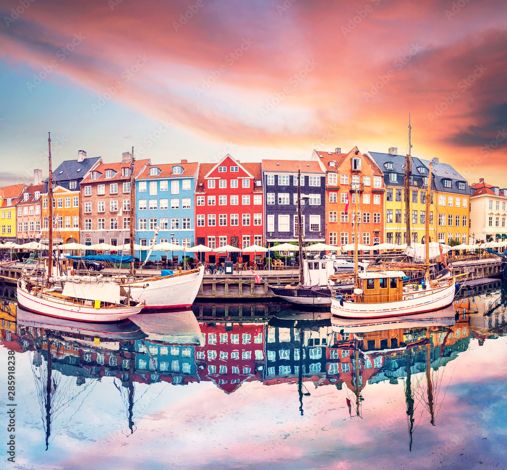 Breathtaking beautiful scenery with boats in the famous Nyhavn in Copenhagen, Denmark at sunrise. Exotic amazing places. Popular tourist atraction. - obrazy, fototapety, plakaty 
