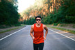 © Andrii - Caucasian middle age man athlete runs sunny summer day on asphalt road in the forest.