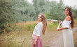 © splitov27 - Two cheerful best girlfriends in retro-style clothes on landing with the road at summer day