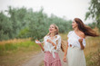 © splitov27 - Two cheerful emotional best girlfriends in retro style clothes in retro clothes walk along the landing with the road on summer cloudy day. Walk together