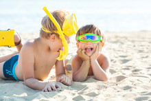 Two Little Children Having Fun On The Beach. Funny Kids Playing On The Sea Shore.