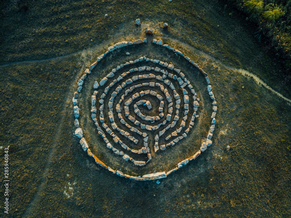 Spiral labyrinth made of stones, top view from drone - obrazy, fototapety, plakaty 