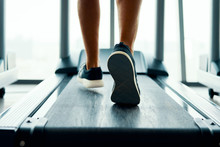Close Up Male Muscular Feet In Sneakers Running On The Treadmill At Gym