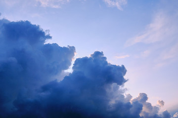 Wall Mural - Thunderclouds are approaching the clear blue sky, copy space. The clouds are dark blue and the evening sky is clear. Weather before coming storm.