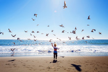 Happy And Free Boy On The Beach With Seagulls