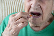 © berna_namoglu - closeup of a senior person taking a vitamin capsule