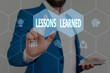 © Artur - Text sign showing Lessons Learned. Business photo showcasing the knowledge or understanding gained by experience Male human wear formal work suit presenting presentation using smart device