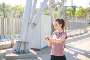 Sticker - Sporty young woman checking her pulse outdoors