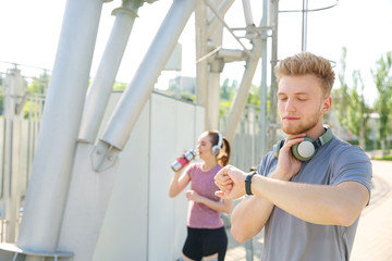 Sticker - Sporty young man checking his pulse outdoors