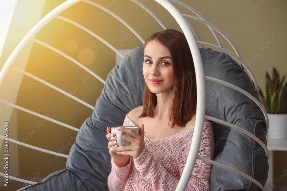 Beautiful young woman drinking tea at home
