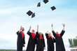 © Pixel-Shot - Happy students in bachelor robes throwing graduation hats outdoors