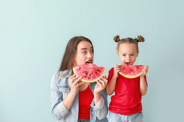 Poster - Beautiful young woman and cute girl with fresh watermelon on color background