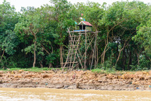 Corrugated Iron Hut On The Top Of A Tall Platform Made From Bamboo And Wooden Stilts, Siem Reap River, Cambodia