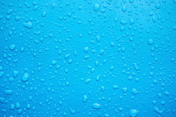  Close up of raindrops, water drops on a polished blue metal surface for background purpose. Selective focus