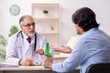 © Elnur - Young male alcoholic visiting old doctor