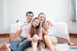 © FrameAngel - little girl smiling with mother and father in front of bed together in bedroom at home, young happy family concept