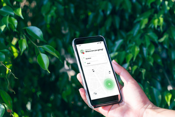 hand holding mobile phone device outdoors to book taxi using ride hailing app - woman booking intern