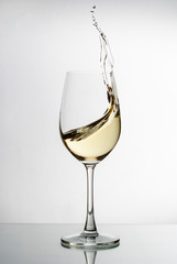 White wine splashing from an elegant wineglass