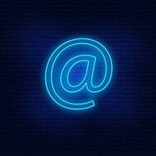 Neon Lights Commercial At, @. Bright Commercial Advertising At . Modern Vector Logo, Banner, Shield, Commercial At, @drawing. Night Advertising On The Background Of A Brick Wall.