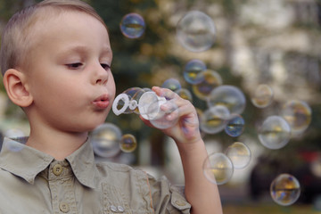 Little boy blowing bubbles. The concept of lifestyle and childhood.