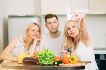 Wall Mural - Friends sitting at table in kitchen