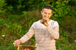 © Olha - Happy beekeeper spends time in apiary. He holds a honeycomb full of bees. One hand is all in the bees