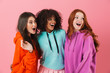 © Drobot Dean - Positive young three multiethnic girls friends posing isolated over pink wall background looking aside.