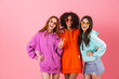 © Drobot Dean - Three happy young girls wearing colorful hoodies standing