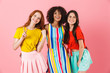 © Drobot Dean - Smiling pleased young three multiethnic girls friends posing isolated over pink wall background.