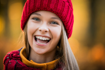 autumn portrait of a girl in a red knitted hat