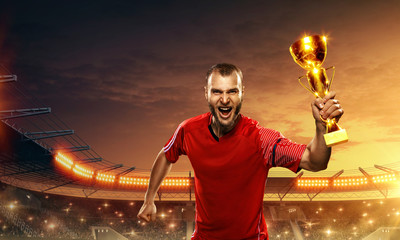 soccer player celebrates championship and holds a trophy