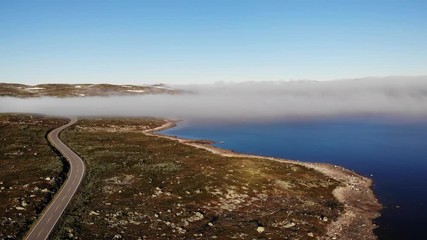 Sticker - Aerial view. Road crossing Hardangervidda mountain plateau, clouds over lakes, morning time. Norway landscape. National tourist Hardangervidda route