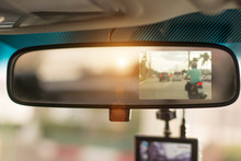 Close Up Car On Highway At Sunset, With Video Recorder Next To A Rear View Mirror,video Recorder Driving A Car On Highway,car Video Recorder,Full HD Camera Recorder For Vehicle.