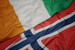 © luzitanija - waving colorful flag of norway and national flag of cote divoire.