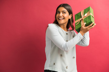 Hispanic Female Shaking Present Against Plain Background