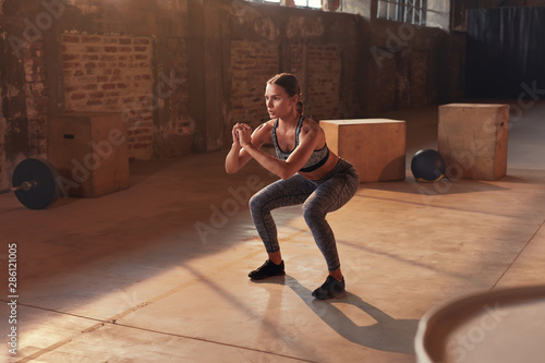 Fotografía Fitness workout. Sport woman doing squat leg exercise at gym
