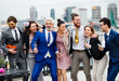 © Halfpoint - A group of joyful businesspeople having a party outdoors on roof terrace in city.