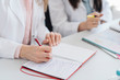 © Westend61 - Crop view of hands of student taking notes in notebook in science class