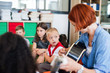 © Halfpoint - A down-syndrome boy with school kids and teacher sitting in class, playing guitar.