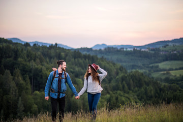 Wall Mural - young tourist couple travellers with backpacks hiking in nature.